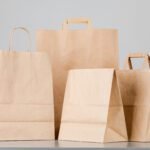 Brown paper bag with handles, empty shopping bag with area for y