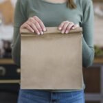 close-up-young-woman-holding-paper-bag