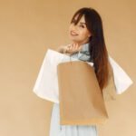 woman-with-shopping-bags-lady-beige-wall-female-blue-jacket